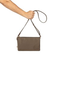 Clutch in nylon marrone con tracolla regolabile, forma rettangolare, superficie liscia, chiusura con zip e una piccola etichetta con logo su un lato.