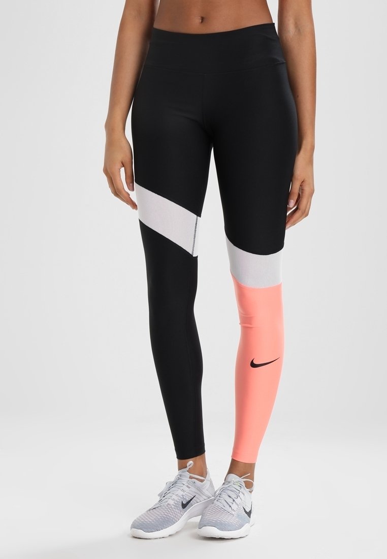 Leggings de sport noirs et roses avec un blocage de couleurs géométrique en noir, blanc et corail. Présente un design ajusté et un logo Nike.