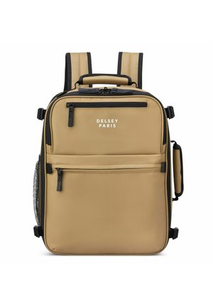 Mochila beige con acentos negros, tela suave, tirantes dobles, asa superior, bolsillos frontales con cremallera y bolsillo lateral de malla para botellas de agua.