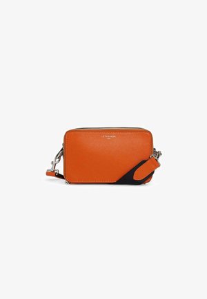 Sac bandoulière en cuir orange avec un accent en tissu noir. Dispose d'une fermeture éclair et d'une sangle amovible. Finition texturée.