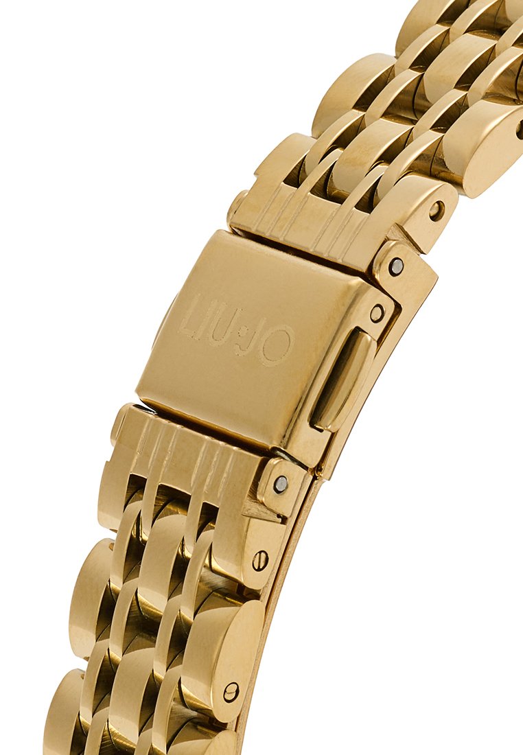 Bracciale in metallo dorato con un design a maglie decorate. Presenta una chiusura con logo inciso e una finitura lucida. Gli accenti includono maglie circolari e piatte.