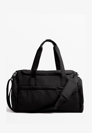Sac de sport noir en nylon avec des poignées doubles, une bandoulière détachable et des poches zippées à l'avant et sur le dessus. Texture lisse.