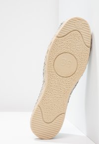 Gray fabric sneaker with a textured rubber sole. The sole features a circular imprint and ridges for grip, labeled "36" and "Made in France."