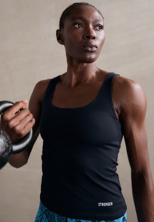 Sort atletisk tanktop med et tætsiddende design, der har en rund halsudskæring og ordet "STRONGER" trykt ved kanten.