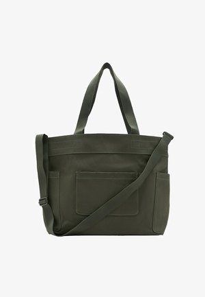 Donkergroene canvas tas met dubbele schouderbanden, voorvak en zijvakken, voorzien van verstelbare lange crossbodyriem.