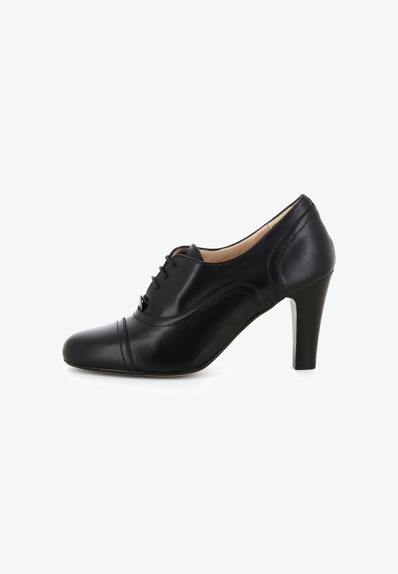 Scarpa nera in pelle con tacco alto, caratterizzata da una punta arrotondata, laccio anteriore e cuciture decorative lungo la parte frontale e i lati.