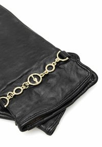 Czarne skórzane rękawiczki z detalem z złotego łańcuszka z okrągłymi ogniwami i zapięciem na przekładkę na białym tle.