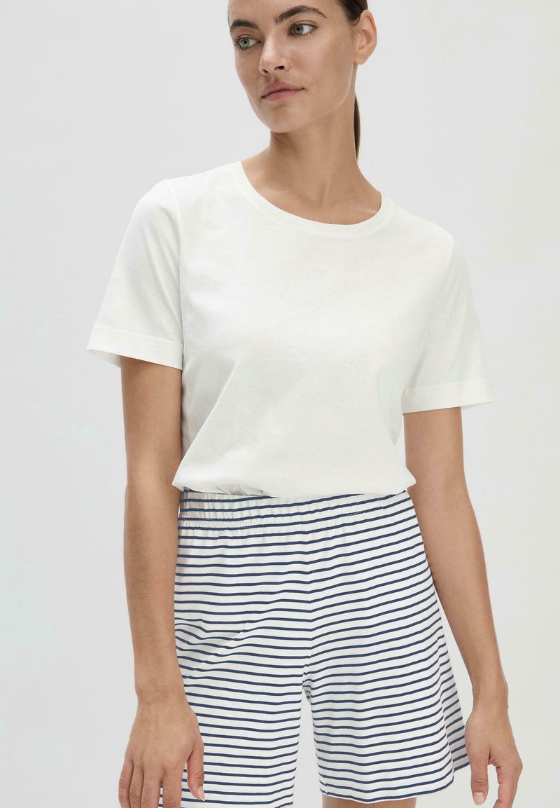 Weißes Baumwoll-T-Shirt mit kurzen Ärmeln, kombiniert mit navy- und weißgestreiften Shorts mit elastischem Bund. Schlichtes, lässiges Design.