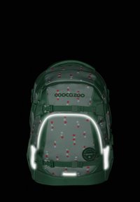 Zaino in tessuto verde con un motivo a pois rossi e bianchi. Presenta dettagli riflettenti, spallacci regolabili e un patch rotondo con logo.