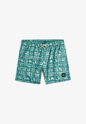 Turkusowe spodenki kąpielowe z białymi tropikalnymi i geometrycznymi wzorami, elastycznym pasem, sznurkiem do wiązania oraz czarną naszywką z logo na lewej nogawce.