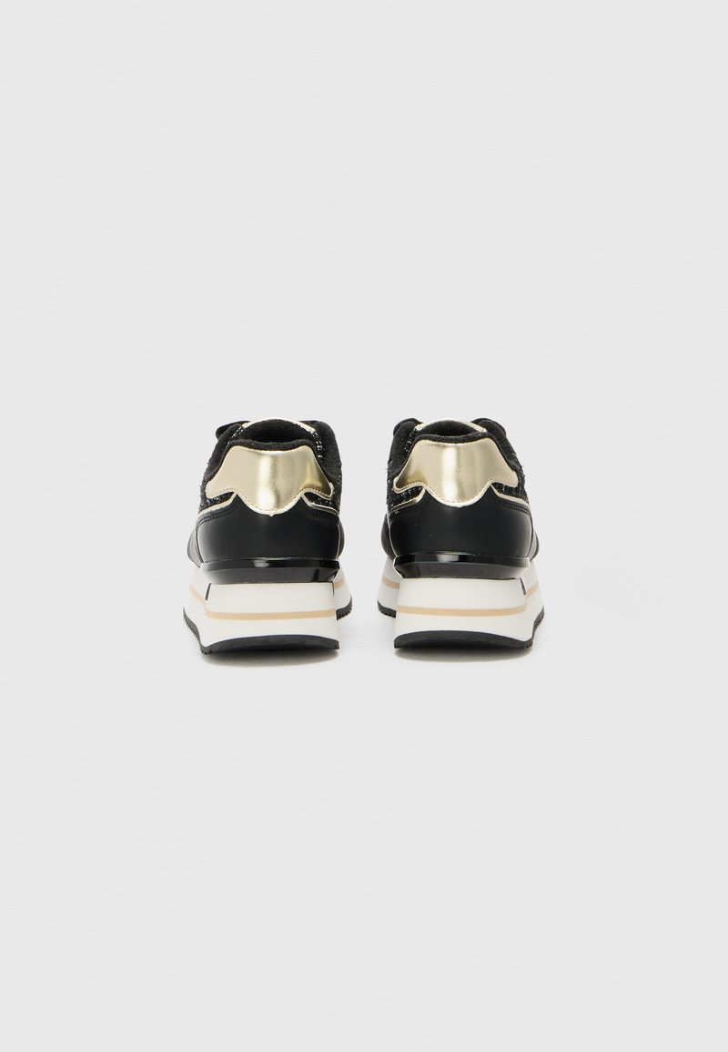 Baskets noires de sport avec des accents métalliques dorés, tige en tissu texturé et épaisse semelle intermédiaire blanche. Présente un bout arrondi et un col rembourré.