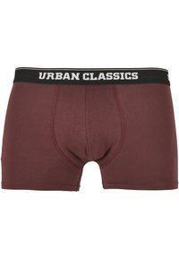 Burgunderfargede boxershorts med en sort elastik som har teksten "URBAN CLASSICS" i hvitt. Laget av et glatt, elastisk materiale.