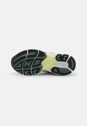 Suela de zapato con bandas de goma negras y verdes y una sección media amarilla, diseñada para tracción y soporte en calzado deportivo.