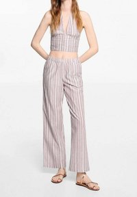 Paski halter crop top i szerokie spodnie z lekkiego materiału. Posiada smockowany fason na górze i elastyczny pas. Kolory obejmują biały, różowy i beżowy.