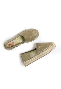 Zielone płócienne espadryle z korkową podeszwą, z podniesionym detalem przeszycia. Wnętrze ma wzór liści w jasnym żółtym kolorze.