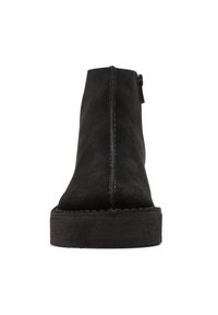 Musta mokkanahkainen nilkkurit, joissa on sileä pinta, pyöreä kärki ja litteä kumipohja. Niissä on sivuvetoketju ja ommeltu yksityiskohtainen viimeistely.