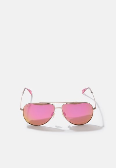 Gafas de sol aviador de metal dorado con lentes espejados rosas, almohadillas nasales transparentes y acentos rosas en las puntas de las patas. Presenta un diseño clásico y una estructura ligera.