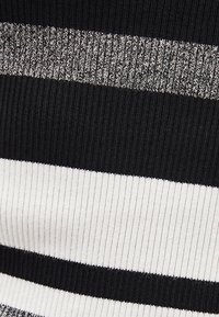 Materiał w czarno-białe paski o prążkowanej fakturze, z naprzemiennymi szerokimi pasami w kolorze czerni i bieli oraz cienkim szarym akcentem.