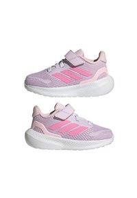 Zapatillas deportivas de color púrpura claro con acentos rosas, parte superior de malla transpirable, correa de Velcro y suela de goma blanca. Presentan tres franjas laterales audaces.