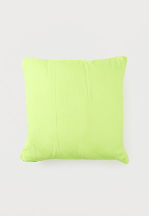 Coussin carré vert citron vif avec une surface en tissu lisse, légèrement froissé, sur un fond clair uni.