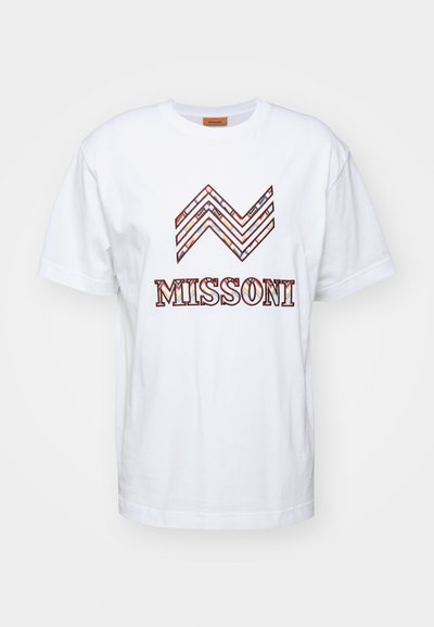 Balta kokvilnas t-krekls ar daudzkrāsainu zīmējumu viļņveidīga raksta formā virs vārda "MISSONI" biezā, stilizētā burtiem. Ar apaļu kakla izgriezumu.