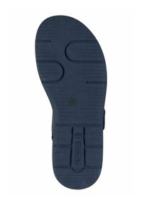 Suola di scarpa in gomma nera con superficie testurizzata, caratterizzata da scanalature e motivi circolari per una migliore aderenza. Marchio centrale visibile.