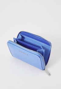 Portafoglio blu in pelle con chiusura a zip, diversi scomparti per carte e hardware in tonalità argentata. Texture liscia con dettagli di cucitura visibili.