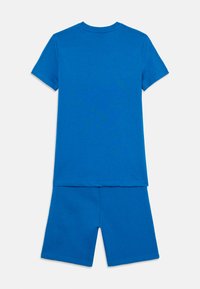 T-shirt blu in cotone a maniche corte con colletto rotondo abbinato a pantaloni corti nello stesso colore. Il tessuto ha una consistenza liscia e morbida.