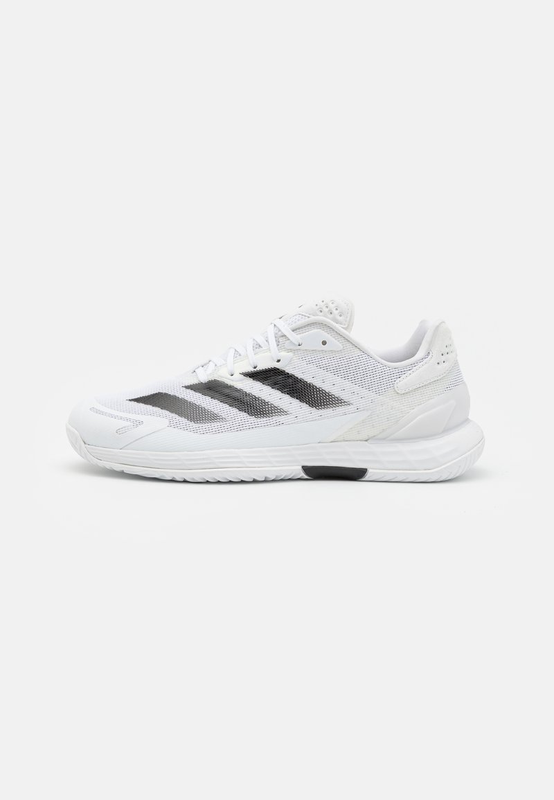 Witte sportschoenen met een bovenwerk van mesh, zwarte accenten, een gevoerd kraagje en een structuurzool voor grip. Lichtgewicht ontwerp voor optimale prestaties.
