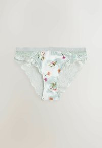 Culotte ornée de dentelle en vert clair avec imprimé floral sur tissu satin, bord festonné et texture douce.