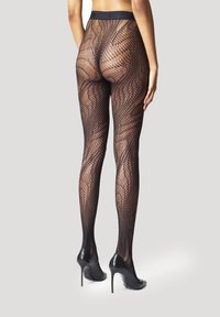 Leggings in rete neri con una texture decorata, caratterizzati da una cintura ampia, progettati per adattarsi perfettamente, abbinati a tacchi alti neri.