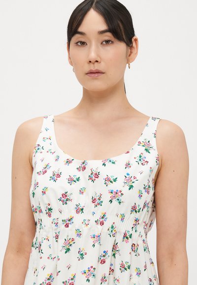 Gėlių rašto vasarinė suknelė iš lengvos medžiagos, su prigludusiu liemeniu, apvalia iškirpte ir spalvingu gėlių raštu ant balto fono.