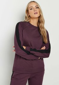 Bordeauxfarbener Sweatshirt mit schwarzen Ärmelakzenten, ausgestattet mit einem gerippten Kragen und Bündchen. Weiches Material mit einer lockeren Passform und Raglanärmeln.