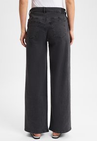 Szerokie, wysokie czarne dżinsy z gładką teksturą, z dwiema tylnymi kieszeniami i szlufką na pasek. Tkanina dżinsowa, casualowy design.