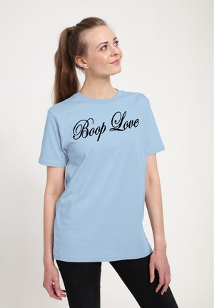 Lyseblå bomulds t-shirt med "Boop Love" i fed sort kursiv skrift på forsiden. Korte ærmer og en afslappet pasform.