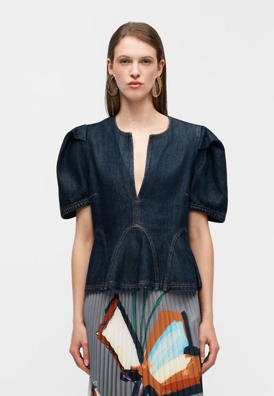 Τζιν τοπ με φουσκωτά μανίκια, βαθύ V-λαιμόκοψη, διακοσμητικές ραφές και φουσκωτή μπορντούρα, σε συνδυασμό με πλισέ φούστα με πολύχρωμο αφηρημένο σχέδιο.