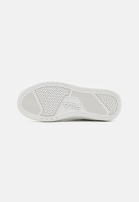 Suola di sneaker bianca con gomma testurizzata per un'ottima aderenza, caratterizzata da un design a motivi e con il logo FILA in rilievo. Forma elegante e minimalista.