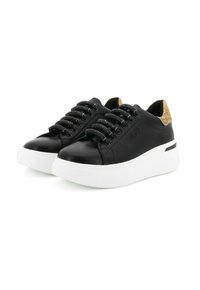 Sneaker in pelle nera con lacci elasticizzati, suola piattaforma bianca e un accento marrone chiaro texturizzato sul tallone. Presenta il nome del marchio in rilievo.