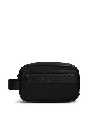 Sort rektangulær toilettaske med lynlås foran, tekstureret øvre sektion, sidehåndtag og lille rød, hvid og blå mærkat på kanten.