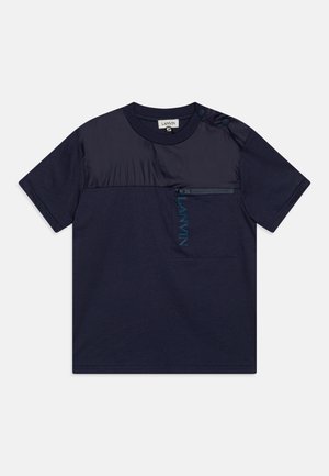T-shirt navy a maniche corte con un pannello in satin a contrasto, tasca con zip e logo ricamato. Presenta un dettaglio con bottoni a pressione sulla spalla.