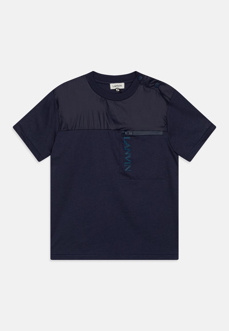 Navy-blaues T-Shirt mit kurzen Ärmeln, kontrastierendem Satin-Einsatz, Reißverschlusstasche und gesticktem Logo. Mit Druckknopfdetail an der Schulter.