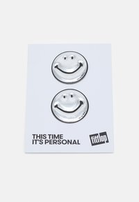 Pins de cara sorridente prateados e redondos em um cartão de fundo branco com texto preto, apresentando uma textura brilhante e um design divertido.