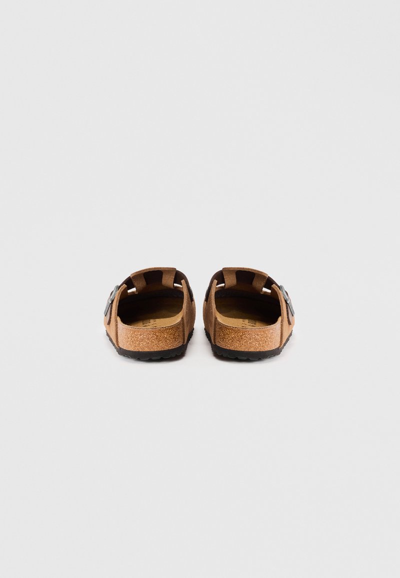 Sandales en daim marron avec semelles en liège et semelles en caoutchouc noir, dotées de straps réglables et de boucles en argent pour un ajustement sécurisé.