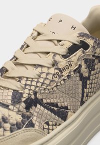 Baskets avec motif peau de serpent beige et noir, lacets beiges, "CPH GN" imprimé près des œillets et sur la languette, semelle épaisse beige.