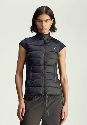 Black puffy sleeveless vest with a high collar, zip closure, subtle branding on the chest, and two side pockets. Smooth fabric texture.