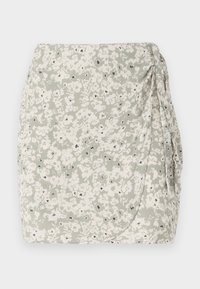 Floral mini skirt in light green and cream with a ruched side and black accent details. Soft, textured fabric with a wrap design.