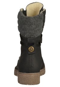 Svart ankelboots med grå fleecekrage, dekorativ rem med metallknapp och texturerad brun sula, visad bakifrån.