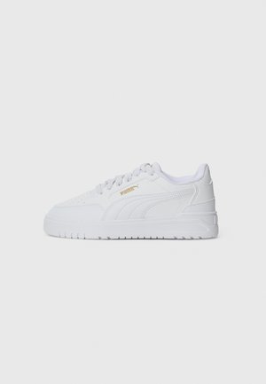 Baskets blanches avec un dessus synthétique lisse, bout arrondi, lacets plats et col rembourré. Comprend un accent de logo doré sur le côté et une semelle texturée.