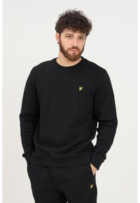 Felpa nera in cotone, con colletto tondo, maniche lunghe e un piccolo logo giallo sul lato sinistro del petto. Tessuto strutturato.