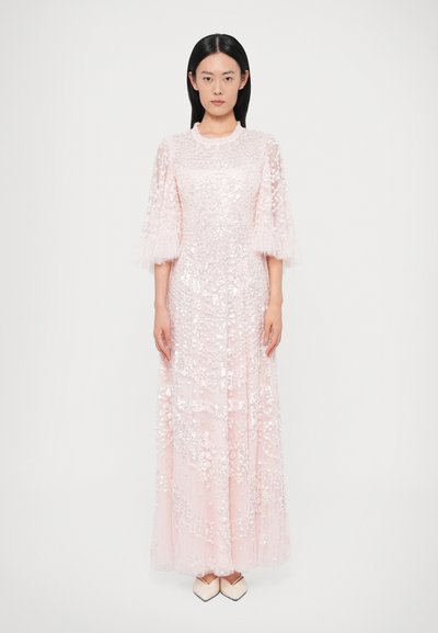 Longue robe rose ornée de sequins avec des manches en tulle transparent, dotée d'un col rond et d'une silhouette fluide. Tissu lisse et texturé.